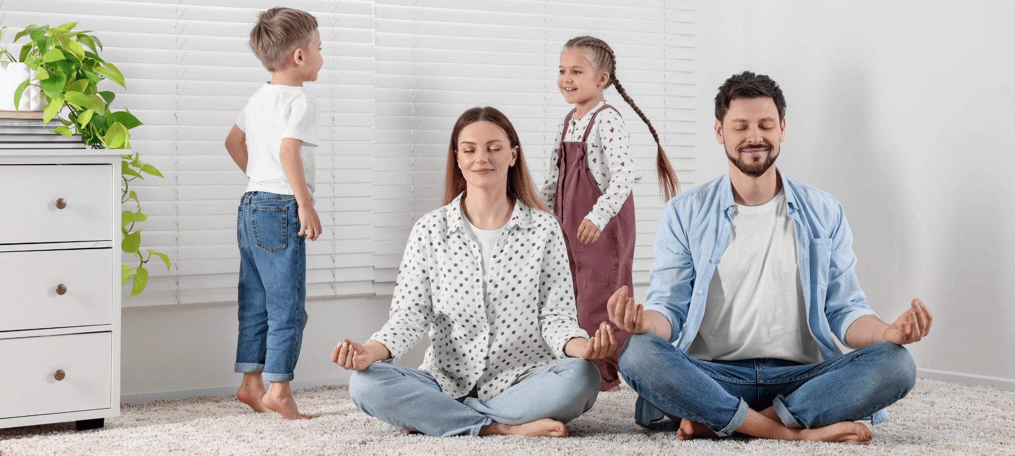 Genitori che fanno yoga con i bambini dietro